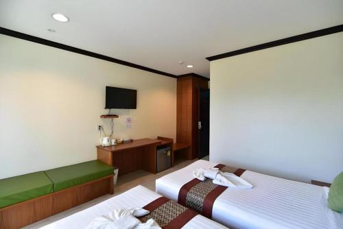 a hotel room with two beds and a tv at The Green Hotel in Ko Lipe
