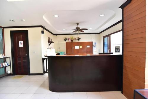a kitchen with a bar with a ceiling fan at The Green Hotel in Ko Lipe