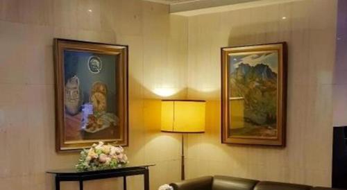 a living room with a couch and two pictures on the wall at Diamond Hotel Tokyo in Tokyo