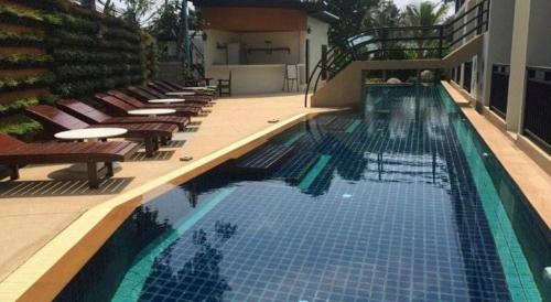 a large swimming pool with lounge chairs and a hotel at The Green Hotel in Ko Lipe