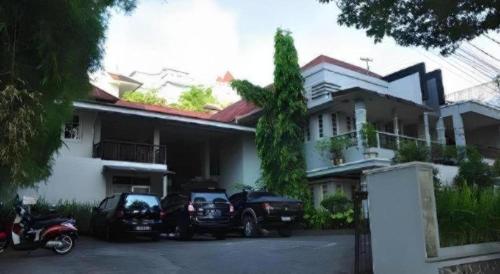 a house with two cars parked in front of it at Hotel Minahasa in Manado