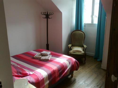 a bedroom with a bed and a chair and a window at Apartment Coecilia in Ax-les-Thermes