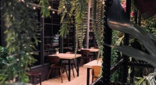 a patio with tables and chairs and plants at Valaya Hotel Pathumthani in Pathum Thani
