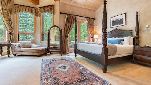 a bedroom with a canopy bed and a chair at Cherry Ridge by AvantStay Incredible Mountain Mansion w Game Room Hot Tub Views in Breckenridge