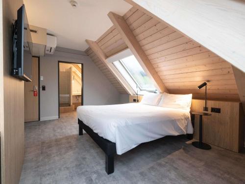 a bedroom with a large white bed and a window at ibis Chur in Chur