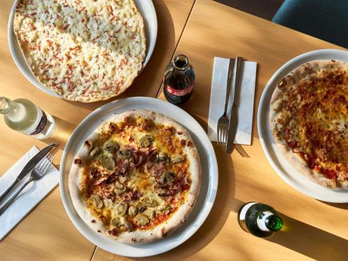 two pizzas sitting on top of a wooden table at ibis Chur in Chur