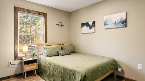 a bedroom with a bed and a window at Lakeview Sunset Heaven Waterfront Escape Private Dock Firepit Game Room New Construction in Blakeslee