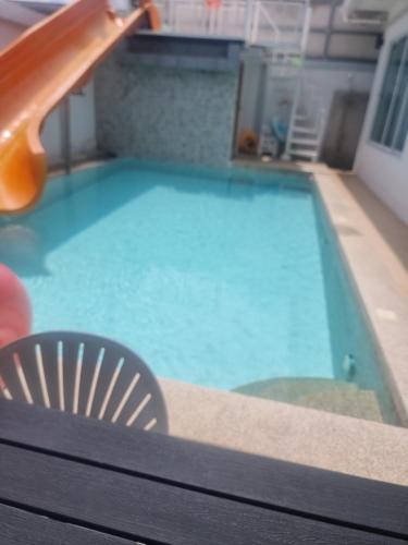 a swimming pool with a slide in the middle of it at The time's pool villa in Ban Bung