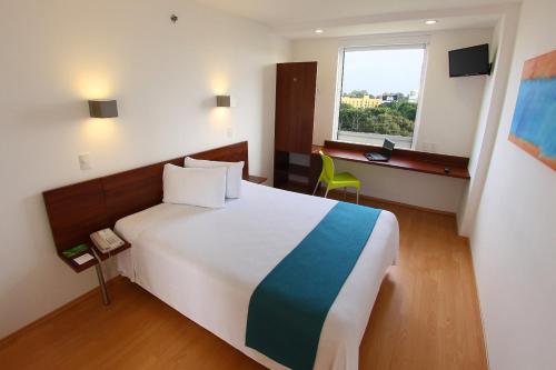 Una cama o camas en una habitación de One Xalapa Las Animas