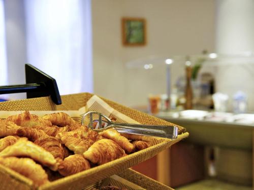 a tray of croissants and other pastries on a table at Novotel Firenze Nord Aeroporto in Sesto Fiorentino