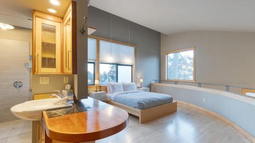 a bedroom with a bed and a sink and a bathroom at Deck Views Fire Pit Pool 3 Mins to Beach Madrona Tree Retreat by AvantStay in Coupeville