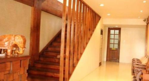 a wooden staircase in a living room with a stair case at Mango Valley Hotel in Olongapo