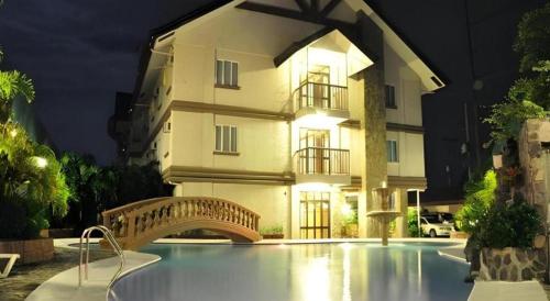 a building with a swimming pool in front of a building at Chocolate and Berries Hotel in Tangos