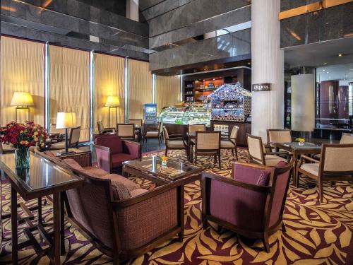 a hotel lobby with tables and chairs and a casino at Novotel Bangkok Bangna in Bangna