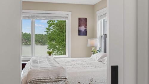 a bedroom with a bed and a large window at Lakeside Serenity by AvantStay Lakefront Newly Built Deck w Views in White Haven