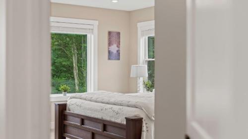 a bedroom with a bed and a window at Lakeside Serenity by AvantStay Lakefront Newly Built Deck w Views in White Haven