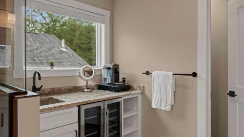 a bathroom with a sink and a window at Lakeside Serenity by AvantStay Lakefront Newly Built Deck w Views in White Haven
