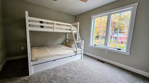 a bedroom with two bunk beds and a window at Lakeside Serenity by AvantStay Lakefront Newly Built Deck w Views in White Haven