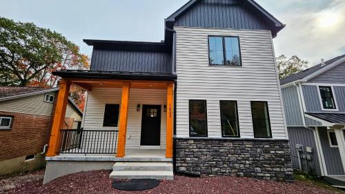 a white house with an orange front porch at Lakeside Serenity by AvantStay Lakefront Newly Built Deck w Views in White Haven