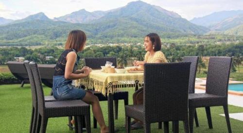 two women sitting at a table with a view at C View Home in Nan