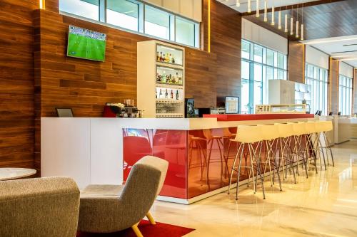 a bar with chairs and a tv on a wall at Fiesta Inn Pachuca Gran Patio in Pachuca de Soto