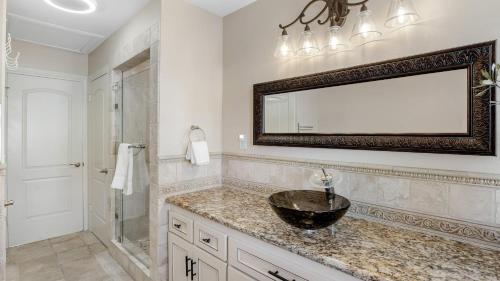 a bathroom with a sink and a mirror on the wall at Bordeaux by AvantStay Private Pool Hot Tub Game Room Near Temecula in Country Road Estates