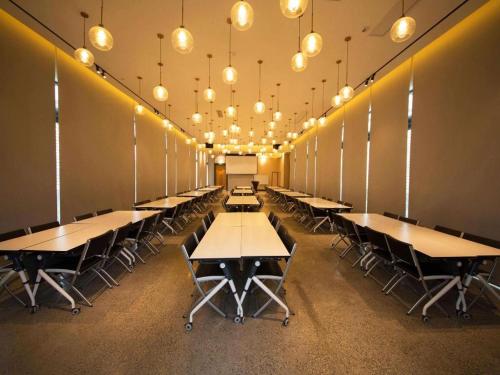 a row of tables and chairs in a room with lights at James Joyce Coffetel Chengdu Jichang Road Shenxianshu in Chengdu