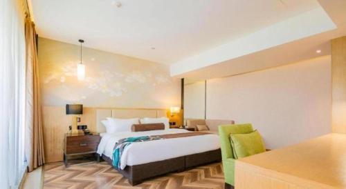 a bedroom with a bed and a desk with a chair at James Joyce Coffetel Chengdu Jichang Road Shenxianshu in Chengdu
