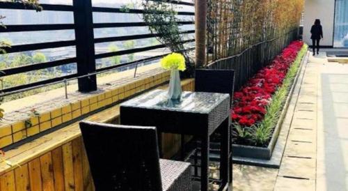 a table with a vase on it on a balcony with flowers at James Joyce Coffetel Chengdu Jichang Road Shenxianshu in Chengdu
