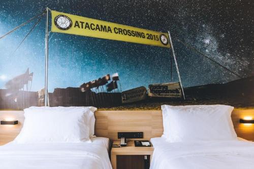 a bedroom with two beds and a sign with a telescope at Shanghai Zeyu Hotel in Shanghai