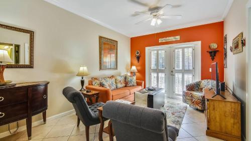 a living room with orange walls and a couch at Coral Palm by AvantStay Key West Walkable Gated Community Shared Pool in Stock Island