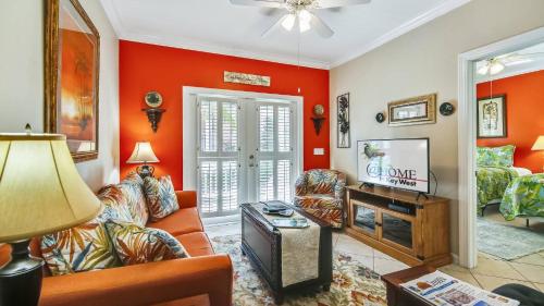 a living room with orange walls and a tv at Coral Palm by AvantStay Key West Walkable Gated Community Shared Pool in Stock Island