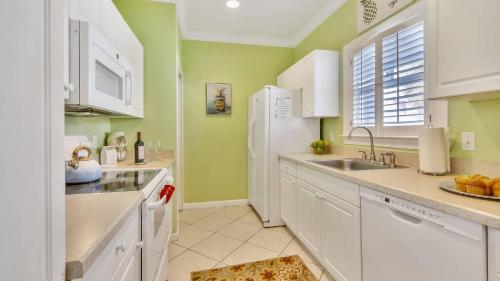 a kitchen with white appliances and green walls at Coral Palm by AvantStay Key West Walkable Gated Community Shared Pool in Stock Island