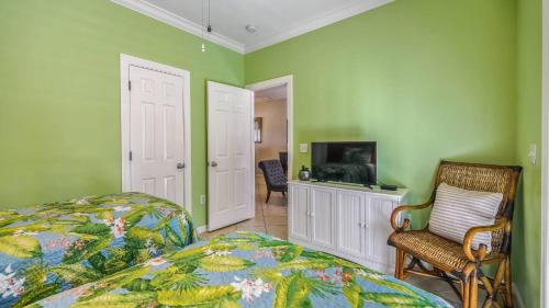 a bedroom with green walls and a bed and a tv at Coral Palm by AvantStay Key West Walkable Gated Community Shared Pool in Stock Island