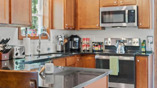 a kitchen with stainless steel appliances and wooden cabinets at Maple Oasis by AvantStay Newly Built w Hot Tub Game Room Fire Pit in Blakeslee