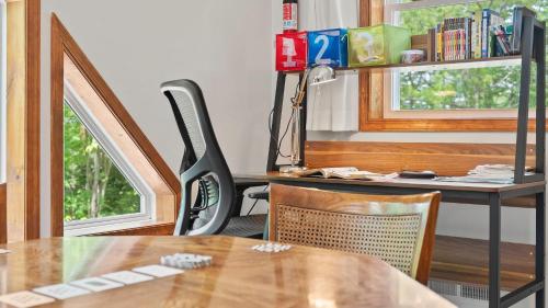a room with a desk with a table and a chair at Maple Oasis by AvantStay Newly Built w Hot Tub Game Room Fire Pit in Blakeslee