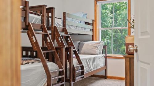 a couple of bunk beds in a room with a window at Maple Oasis by AvantStay Newly Built w Hot Tub Game Room Fire Pit in Blakeslee