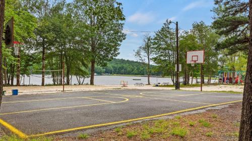 a basketball court with a basketball hoop on a lake at Maple Oasis by AvantStay Newly Built w Hot Tub Game Room Fire Pit in Blakeslee
