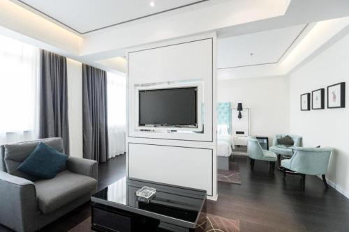 a living room with a television and a living room with a couch at Xana Hotelle Xi'an GONG IP South Gate of Zhonglou in Xi'an