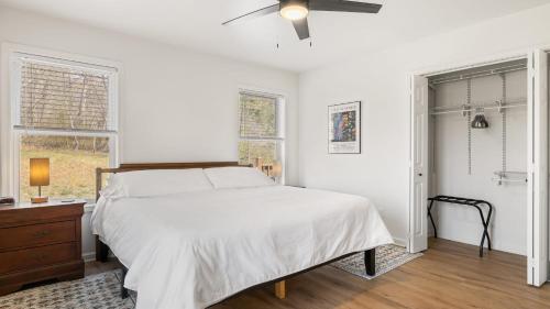 a white bedroom with a bed and a ceiling fan at Little Pisgah Sunrise by AvantStay Mountain View in Fairview