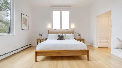 a white bedroom with a large bed and two windows at Malvasia by AvantStay Luxe Wine Country Retreat in Santa Rosa