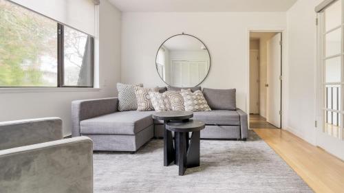 a living room with a couch and a round mirror at Malvasia by AvantStay Luxe Wine Country Retreat in Santa Rosa