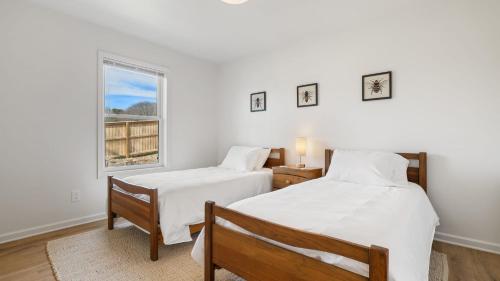 two beds in a room with a window at Little Pisgah Sunrise by AvantStay Mountain View in Fairview