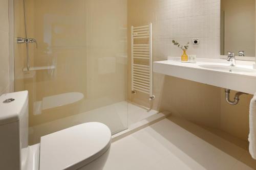 a white bathroom with a toilet and a sink at La Concha Suite 2 by FeelFree Rentals in San Sebastián