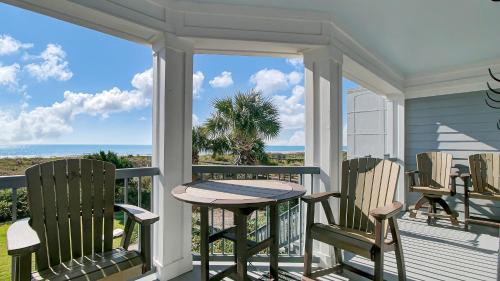 a porch with a table and chairs and the ocean at Beachfront 3BDR Condo with Pool & Deck Ocean Views Ocean Blvd #102 by AvantStay in Isle of Palms