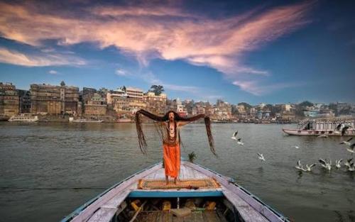 a person on the back of a boat in the water at Shubhang guest house in Varanasi