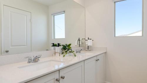 a white bathroom with two sinks and a mirror at Desert Eden by AvantStay 6BR w Ensuite Backyard Oasis w Pool Hot Tub in Coachella