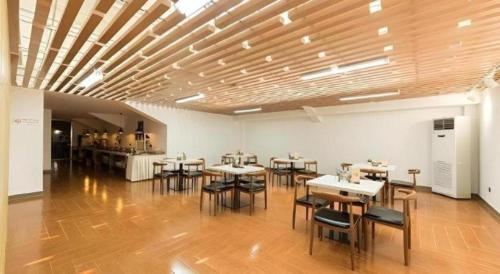 a group of tables and chairs in a room at Jinjiang Inn Select Xuzhou High-speed Railway Station Kunpeng Road in Xuzhou
