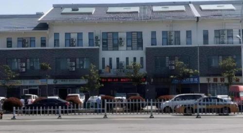 a large building with cars parked in front of it at Jinjiang Inn Select Xuzhou High-speed Railway Station Kunpeng Road in Xuzhou