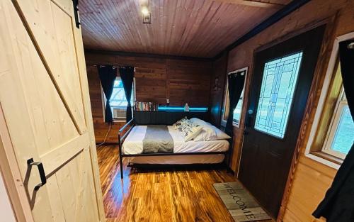 Un pequeño dormitorio con una cama en una habitación de madera. en Nickz Cozy Cabin, en Fenton